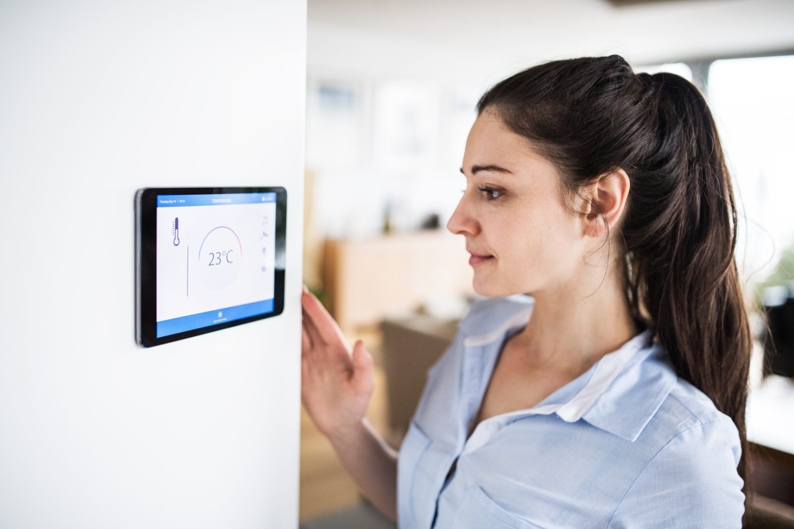 A woman looking at tablet with smart home screen.